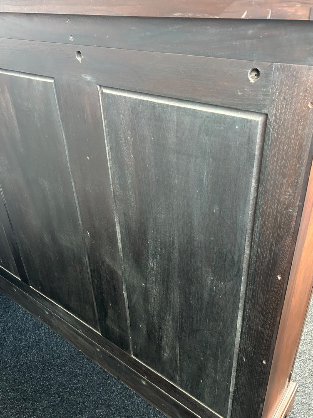 A large mahogany three-door glazed bookcase featuring geometric astragal glazing bars, carved oval motifs, and bracket feet. View VII