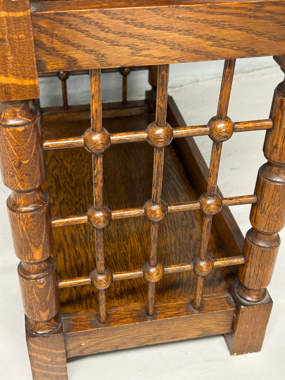 An antique warm brown oak book stand featuring a slanted top reading surface, two lower shelves, and turned spindle side galleries. View IV