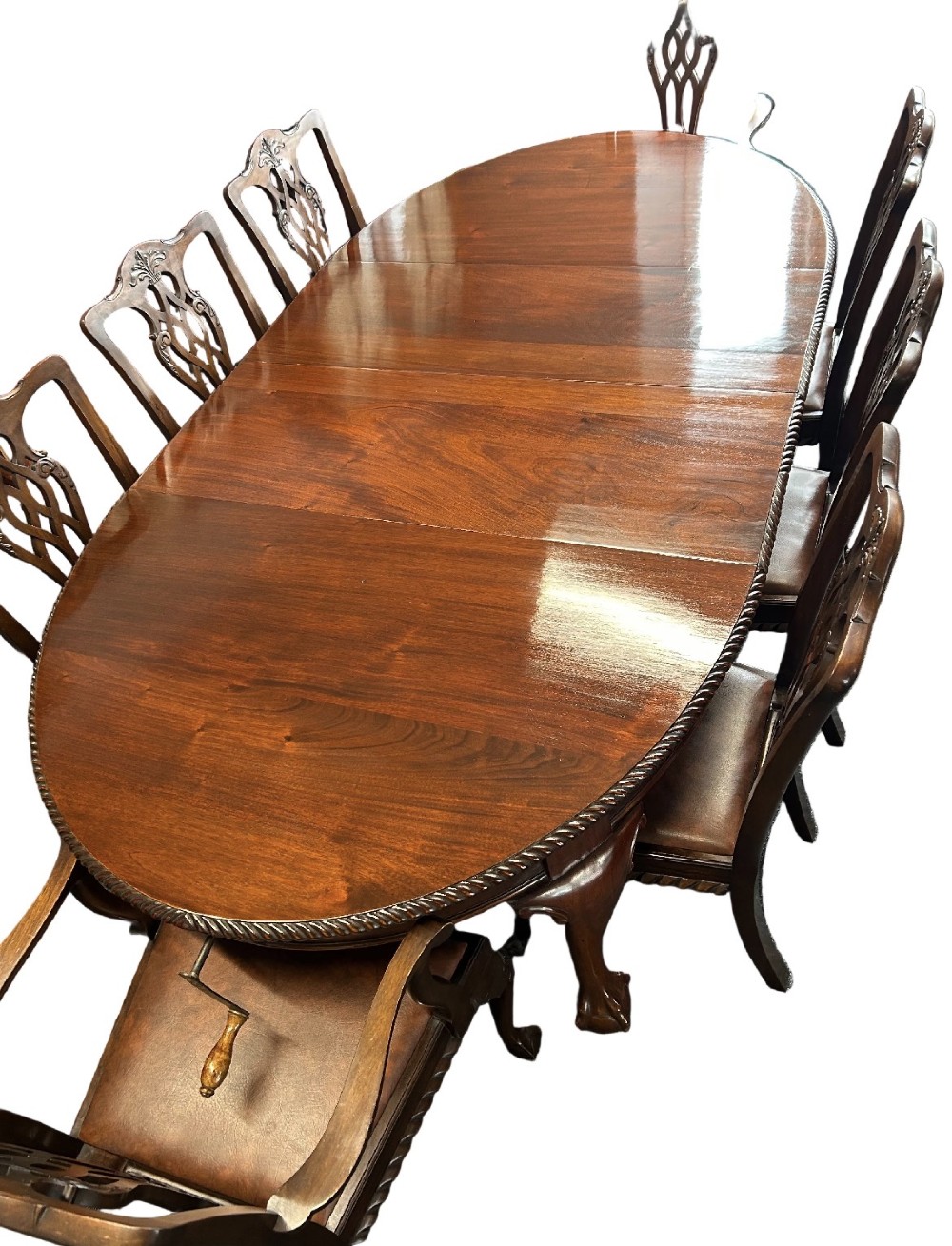 An extending mahogany dining table featuring a carved rope edge and cabriole legs, surrounded by eight Chippendale style chairs with pierced back splats. View II