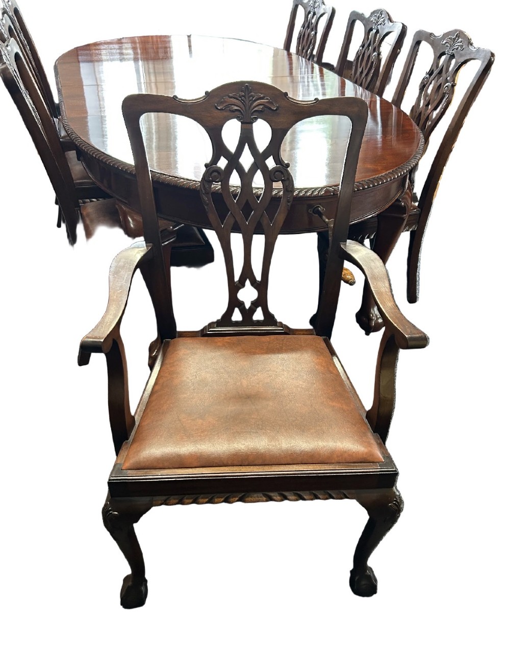 An extending mahogany dining table featuring a carved rope edge and cabriole legs, surrounded by eight Chippendale style chairs with pierced back splats. View III
