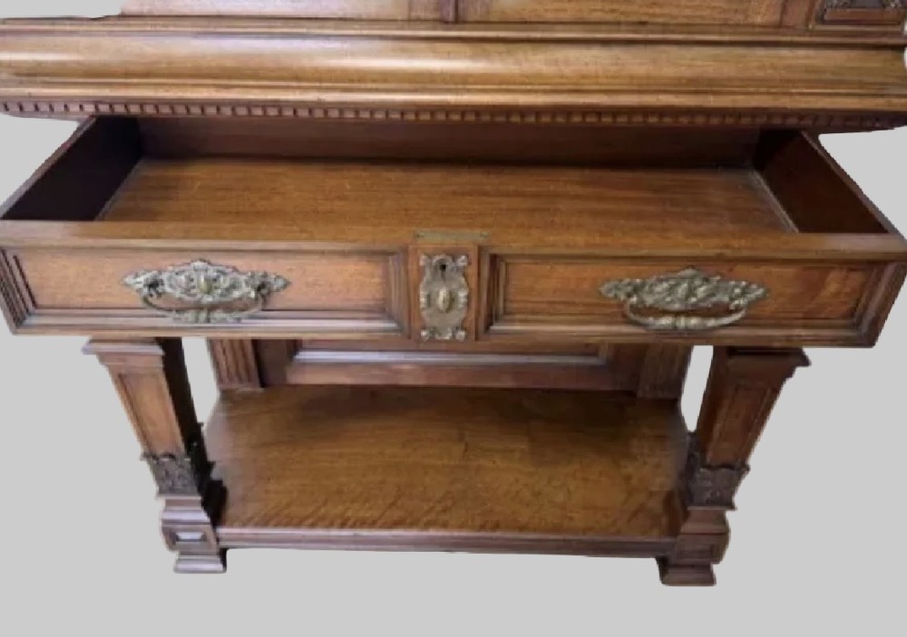 A 19th-century Renaissance Revival carved wood cabinet-on-stand with intricate relief carvings, twin doors, upper drawers, and an open lower shelf. View V