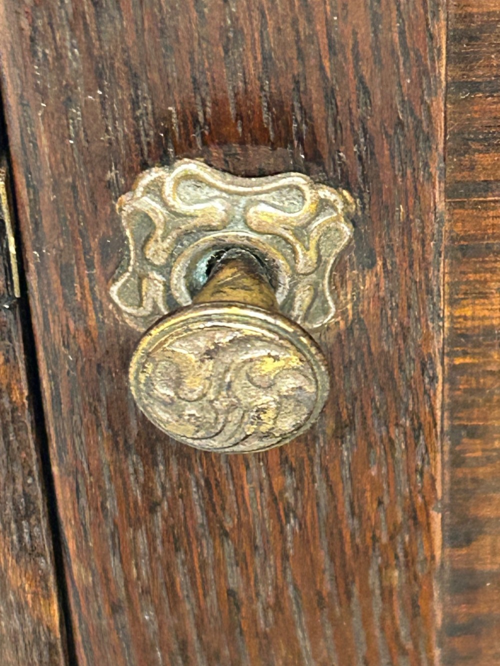 An Arts and Crafts dark oak purdonium featuring stylized carved leaf panels, an upper cupboard, an open shelf, and a slanted fall-front compartment. View VIII