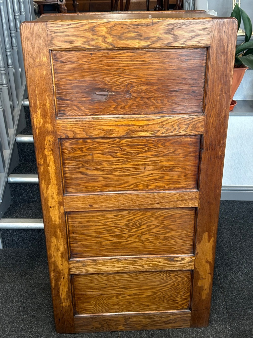 A vertical four-drawer golden oak filing cabinet featuring brass label holders and metal pull handles. View III
