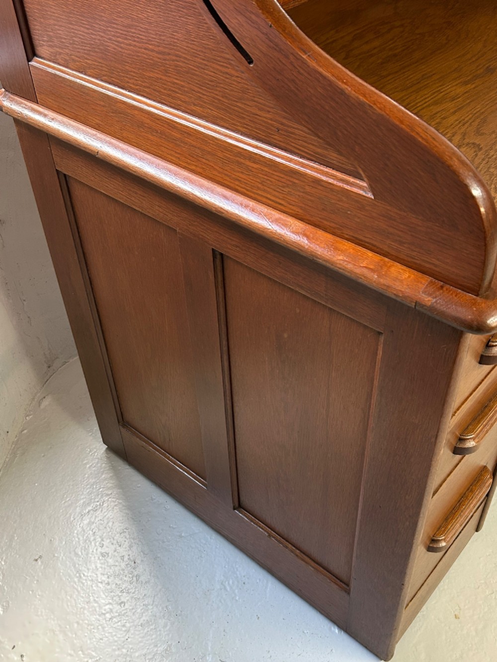 A warm brown oak roll top desk featuring a tambour slatted shutter top, central drawers, and twin pedestals with integrated storage drawers. View IV