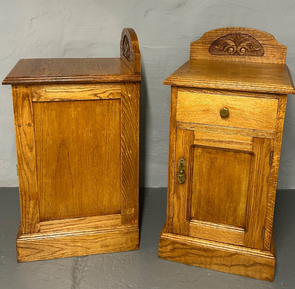 A matching pair of light oak bedside cabinets featuring carved crest galleries, single drawers, single panel doors, and brass fittings. View II