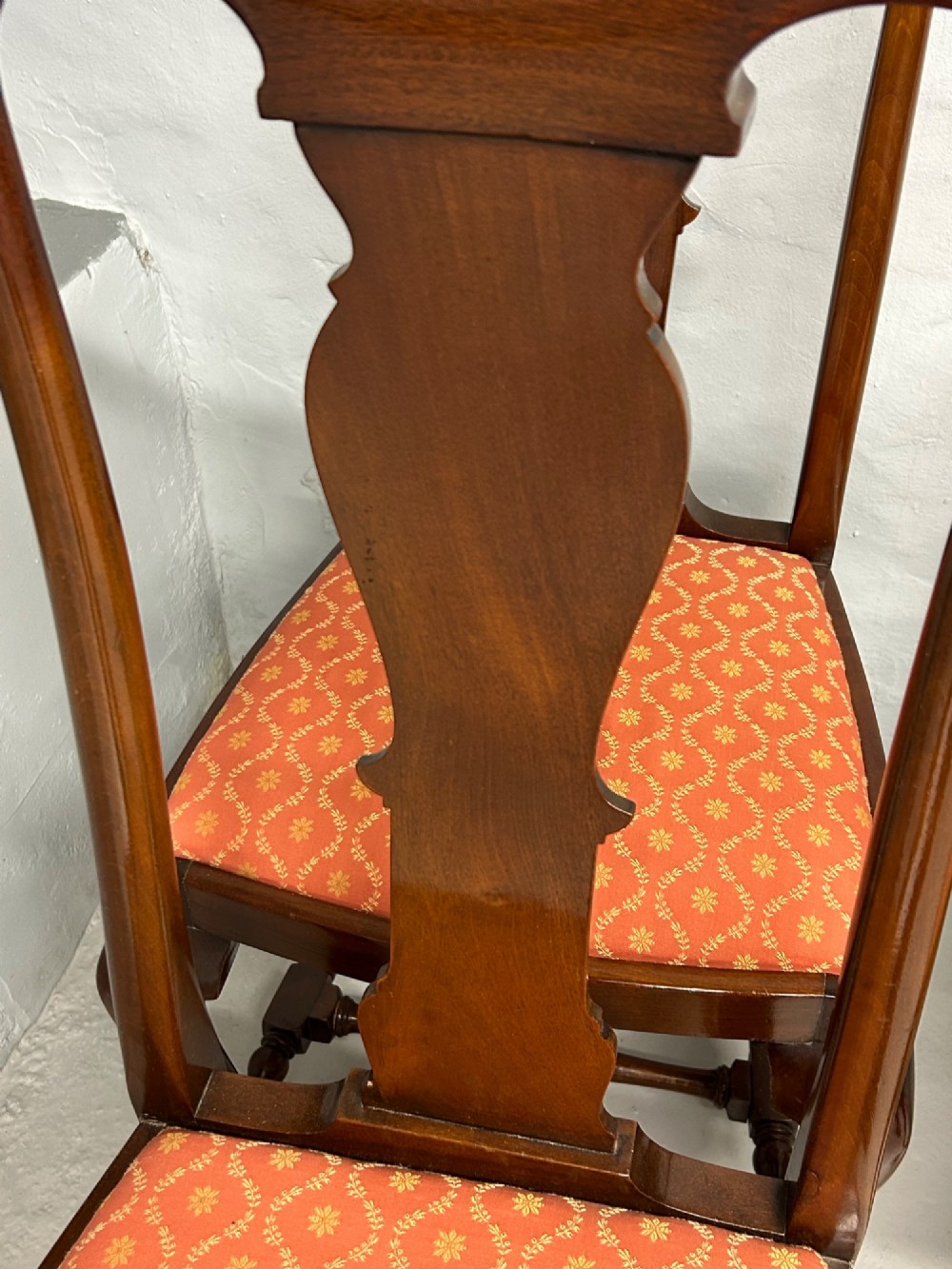 A set of five dark mahogany Queen Anne style dining chairs featuring vase-shaped splat backs, cabriole legs, and patterned terracotta fabric seats. View VI