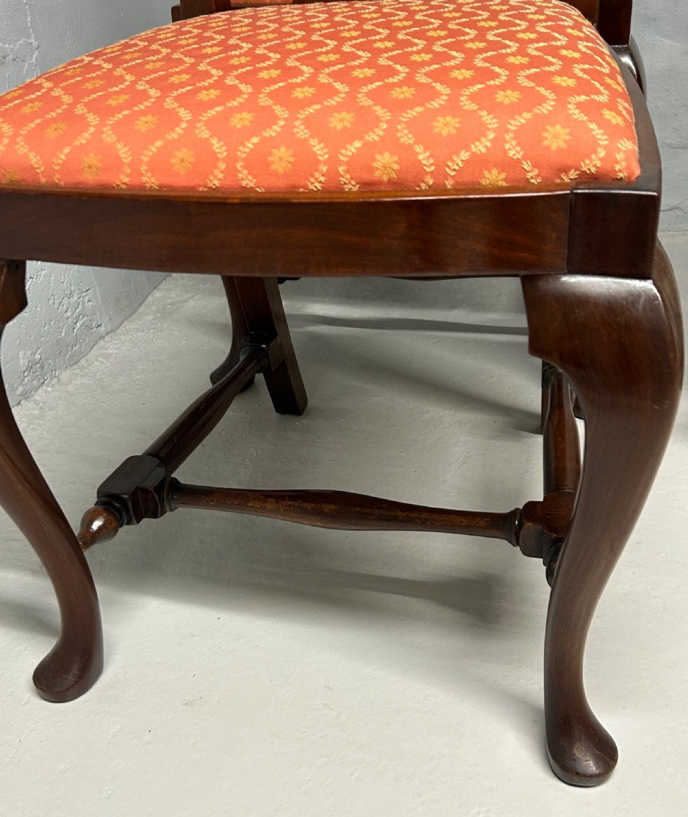 A set of five dark mahogany Queen Anne style dining chairs featuring vase-shaped splat backs, cabriole legs, and patterned terracotta fabric seats. View VII