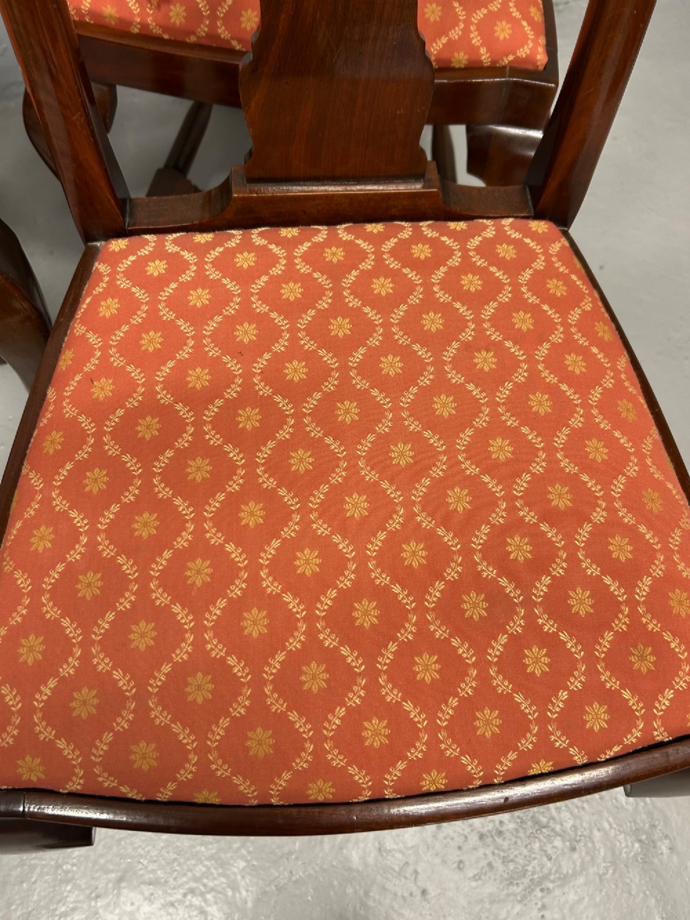 A set of five dark mahogany Queen Anne style dining chairs featuring vase-shaped splat backs, cabriole legs, and patterned terracotta fabric seats. View VIII