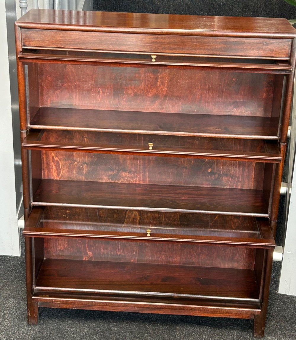 A three-tier mahogany barrister bookcase featuring glazed front doors and small circular brass knobs. View II