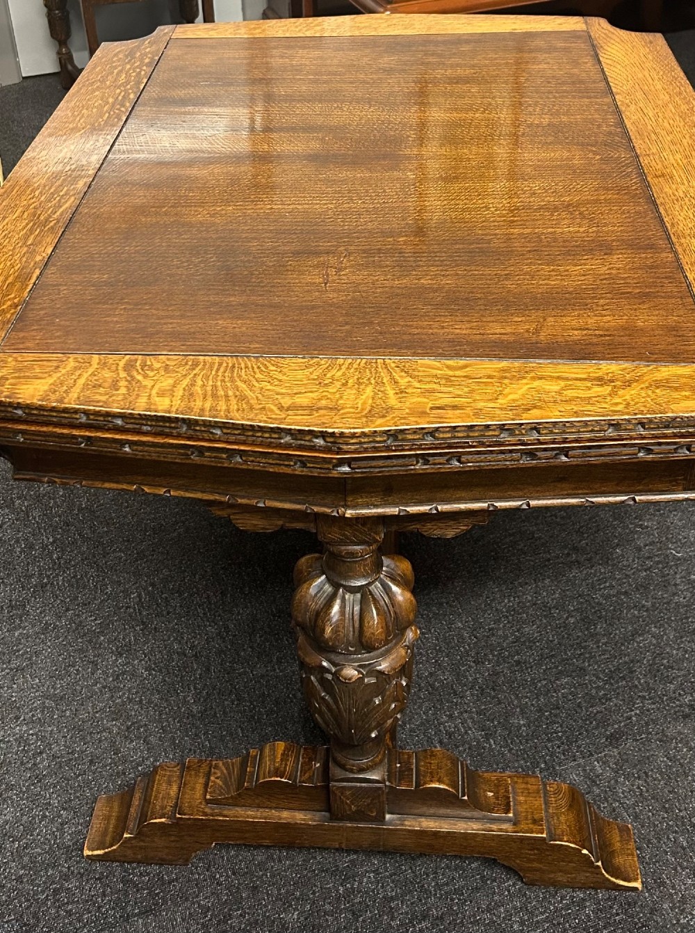 An Art Deco dark oak dining table featuring carved legs paired with four matching chairs with patterned upholstered seats. View III