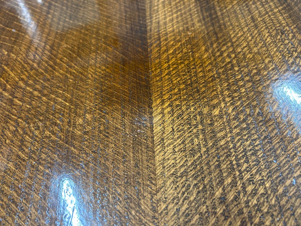 An Art Deco dark oak dining table featuring carved legs paired with four matching chairs with patterned upholstered seats. View VII
