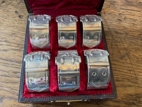 SET OF SIX CASED ANTIQUE NAPKINS RINGS MODELLED AS BELT BUCKLES