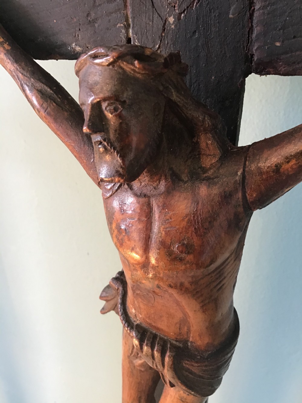 A hand-carved wooden standing crucifix featuring a detailed Corpus Christi figure mounted on a dark ebonised wooden cross with a tiered base. View VII