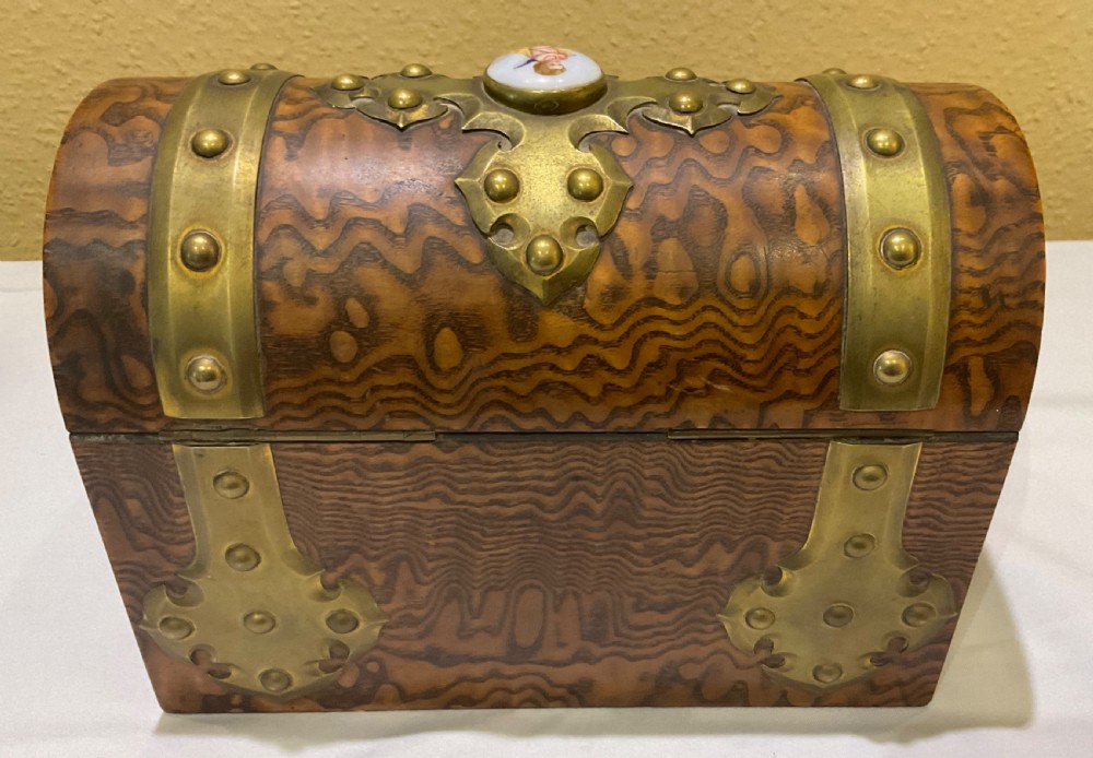 A Victorian domed walnut casket featuring brass strapwork, decorative studs, keyhole escutcheon, and porcelain cabochons with painted cherubs. View III