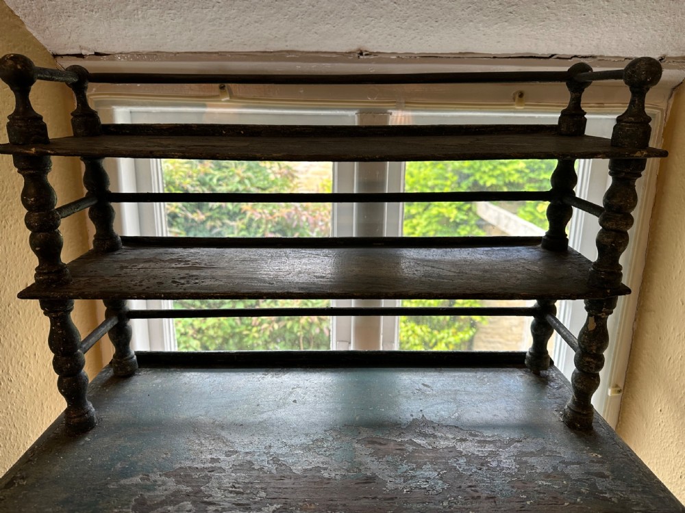An antique French dark green painted miniature dresser featuring a tiered spindle plate rack above a single drawer and twin arched panel cupboard doors. View II