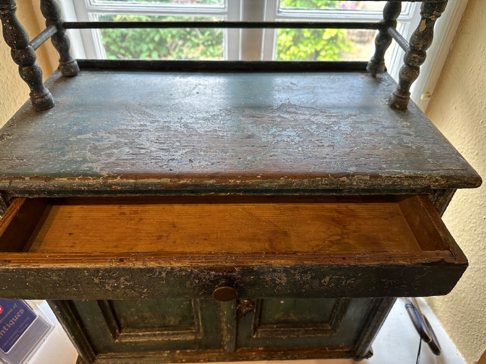 An antique French dark green painted miniature dresser featuring a tiered spindle plate rack above a single drawer and twin arched panel cupboard doors. View VI