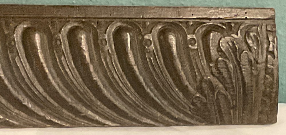 A long rectangular 17th-century carved dark oak frieze panel with repeating diagonal fluting and leaf end motifs. View II