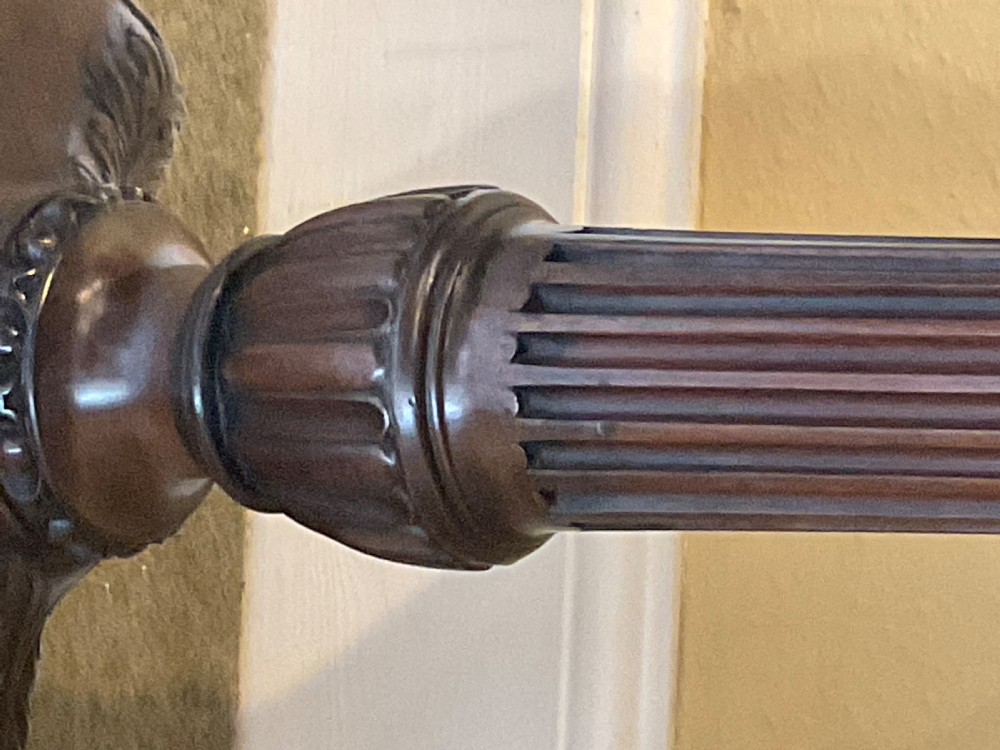 A nineteenth-century mahogany tripod table featuring a scalloped piecrust top, a fluted column, and carved cabriole legs terminating in claw feet. View VI