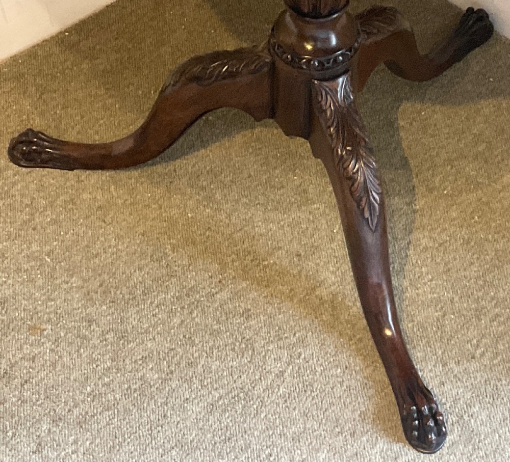 A nineteenth-century mahogany tripod table featuring a scalloped piecrust top, a fluted column, and carved cabriole legs terminating in claw feet. View VII