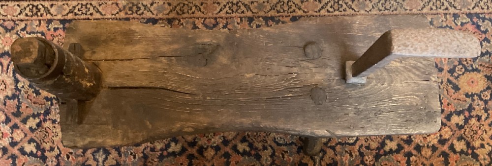 A rustic dark oak cobbler bench featuring a thick timber top with integrated iron tools and sturdy wooden leg supports. View III