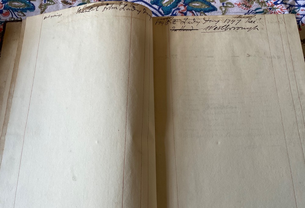 An 18th-century dark brown leather-bound ledger featuring a central gilt oval wreath cartouche with the word RENTAL stamped in gold. View II