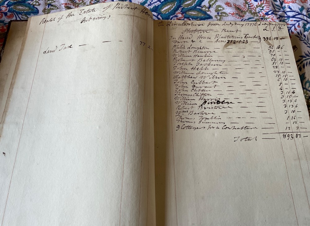 An 18th-century dark brown leather-bound ledger featuring a central gilt oval wreath cartouche with the word RENTAL stamped in gold. View VI