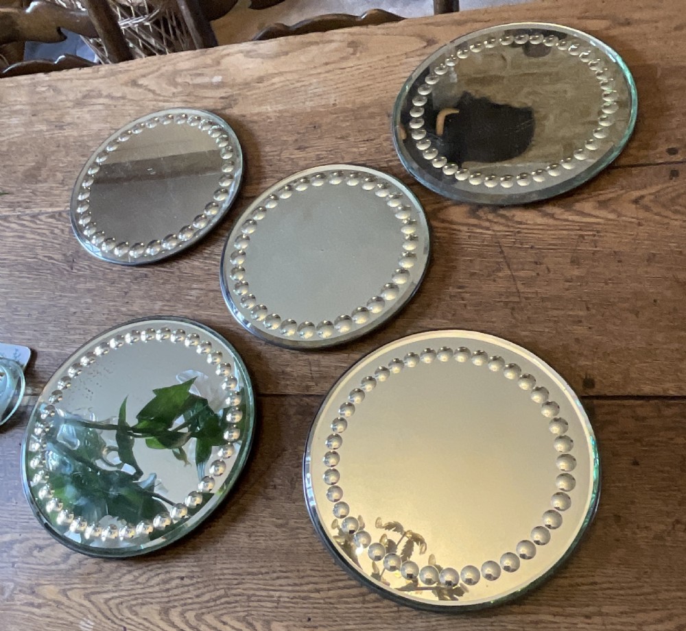 A collection of five circular convex sorcerer mirrors featuring beaded glass border detailing. View V