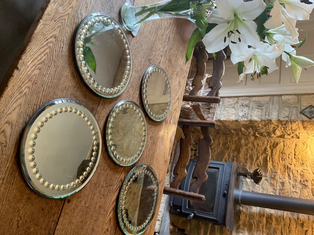 A collection of five circular convex sorcerer mirrors featuring beaded glass border detailing. View VI