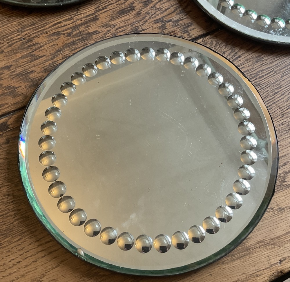 A collection of five circular convex sorcerer mirrors featuring beaded glass border detailing. View VIII