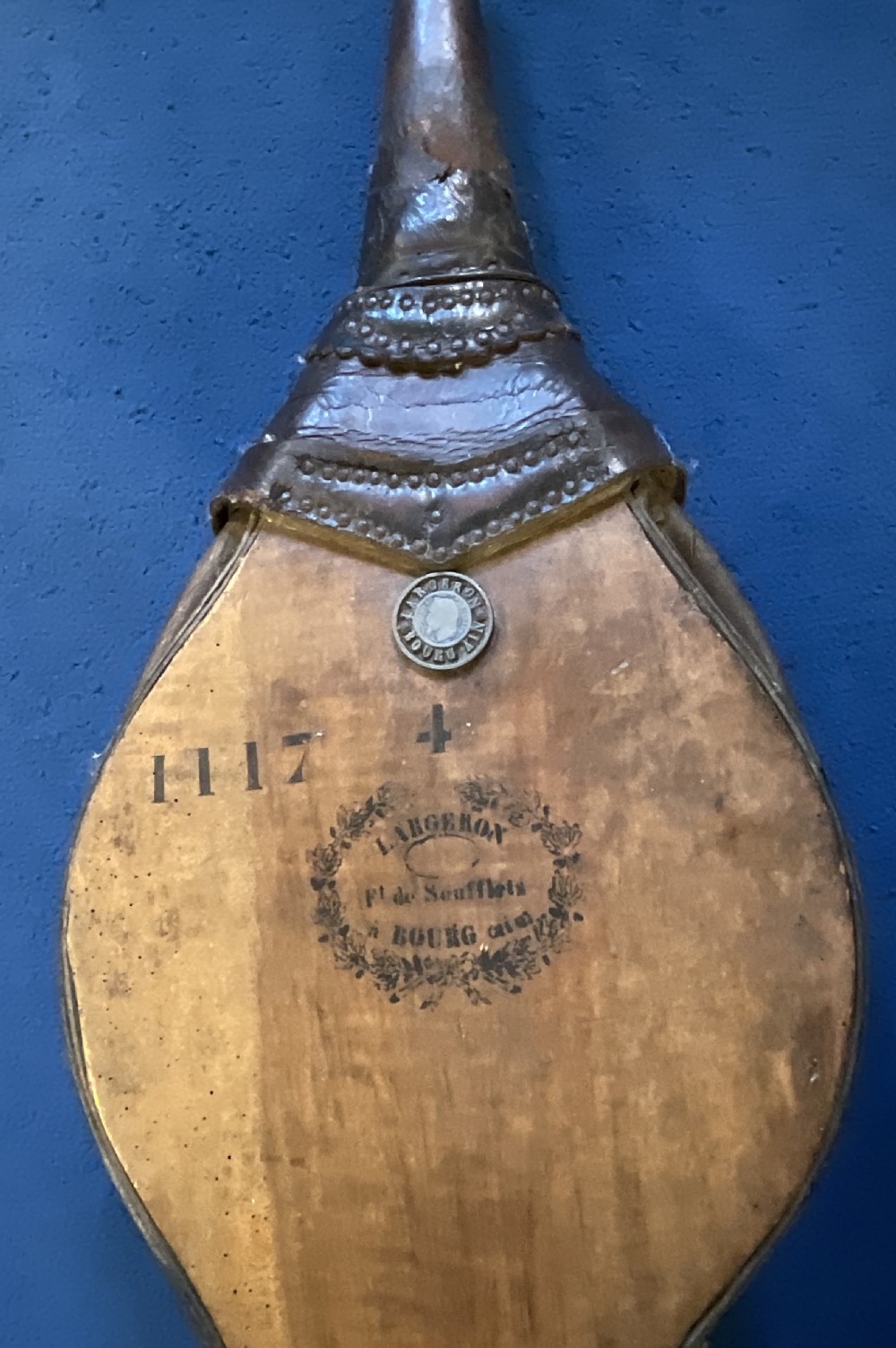 Antique French wooden fireplace bellows featuring dark leather trim, metal nozzle, and maker stamp printed on the wooden body. View IV