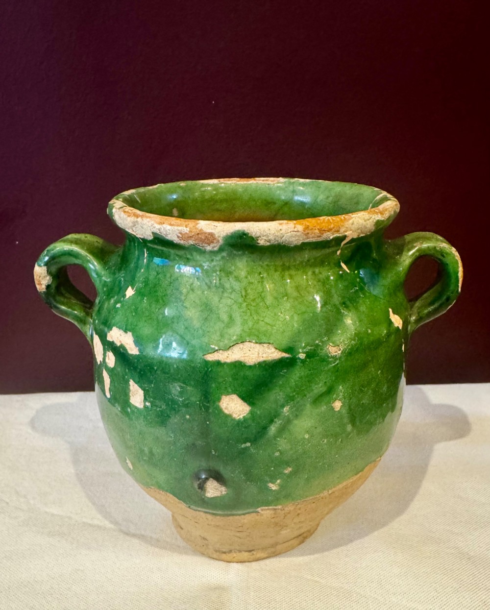 An antique French terracotta confit pot featuring a green glaze on the upper body, two loop handles, and an unglazed earthen base. View II