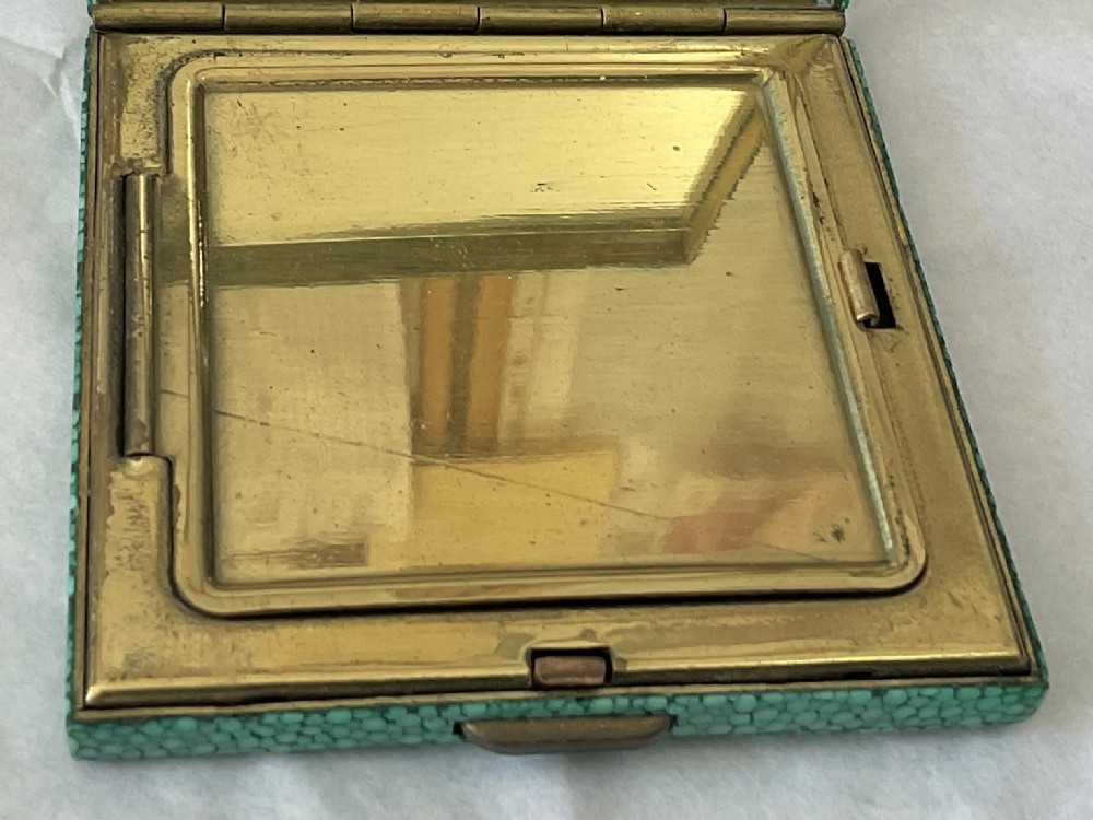 A square Art Deco vanity compact covered in green dyed shagreen with a brass catch. View III