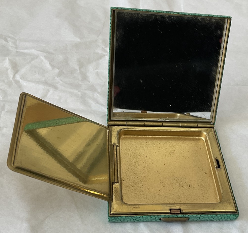 A square Art Deco vanity compact covered in green dyed shagreen with a brass catch. View IV