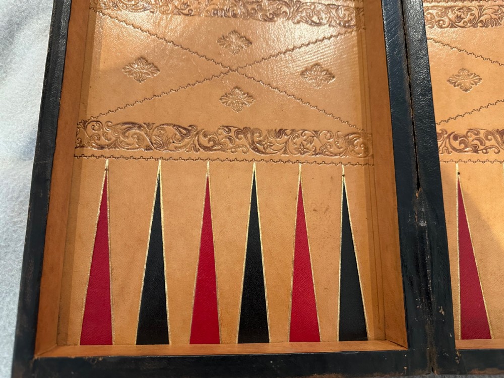 An antique closed leather-bound faux book games board decorated with a black and tan chequerboard pattern and gilt-tooled borders. View VIII