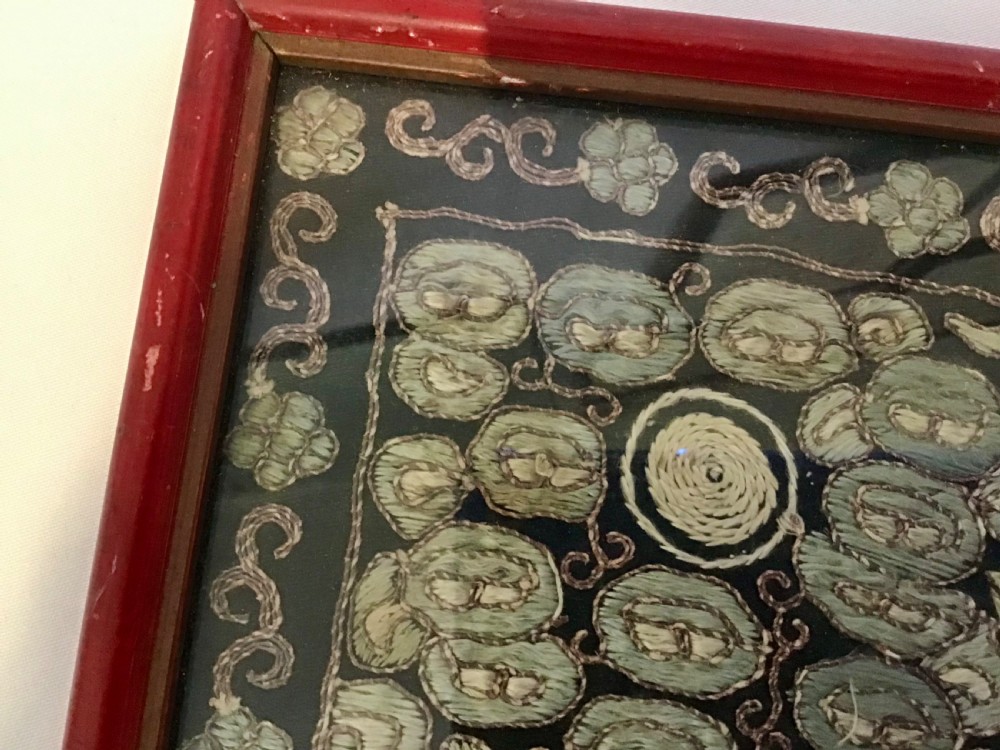A square framed Chinese silk rank badge featuring a central embroidered bird surrounded by clouds, bats, and water waves in cream silk thread against a dark background. View IV