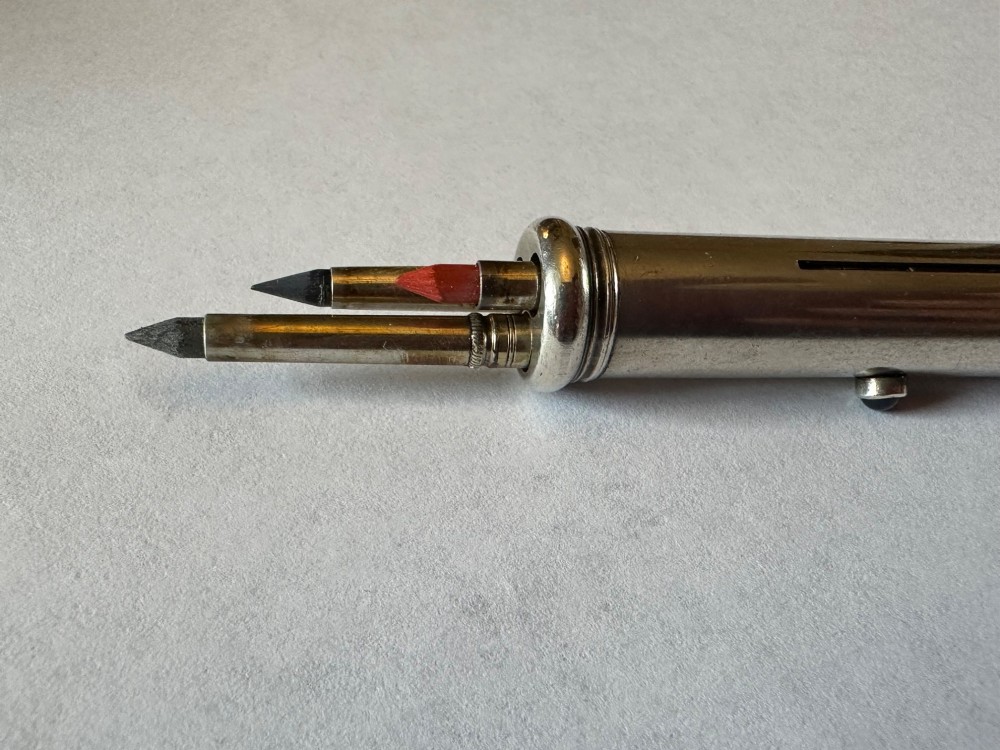 An antique Sampson Mordan sterling silver three-colour propelling pencil featuring side slider mechanisms and a top suspension ring. View III
