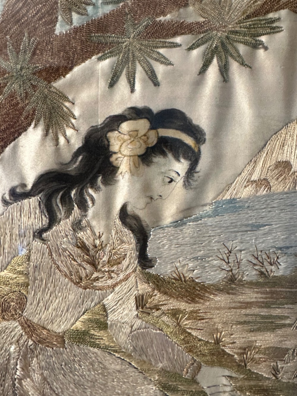 An oval Regency embroidered silk picture depicting a shepherdess and sheep under a tree within a gilded frame. View V