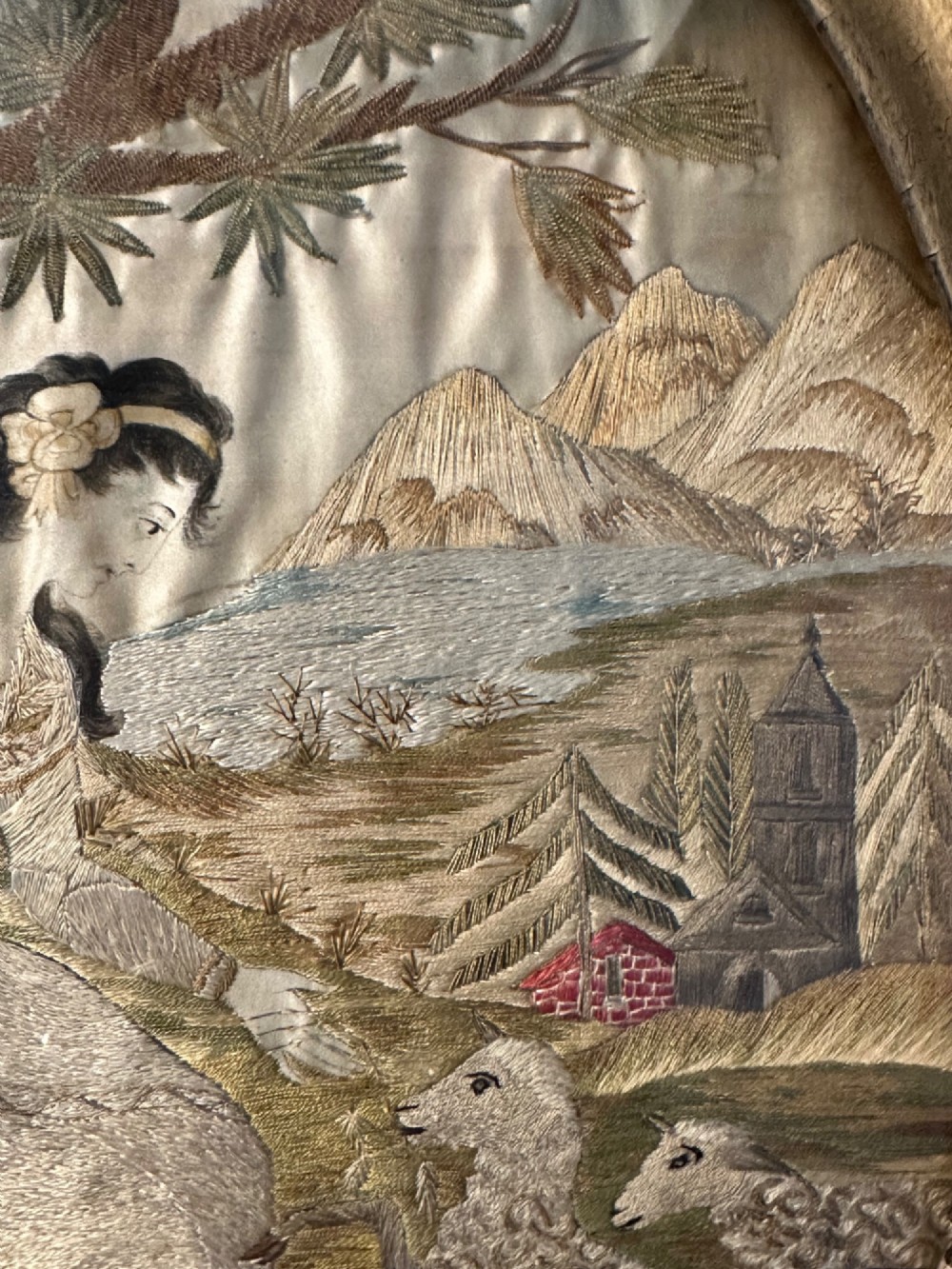 An oval Regency embroidered silk picture depicting a shepherdess and sheep under a tree within a gilded frame. View VI
