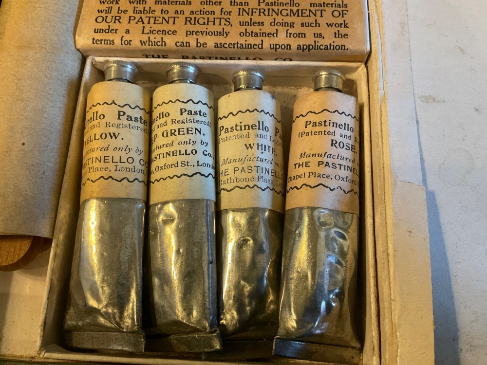 An open early 20th-century Workers Pastinello Outfit cardboard box containing paint tubes, a broad brush, and paper instructions. View IV