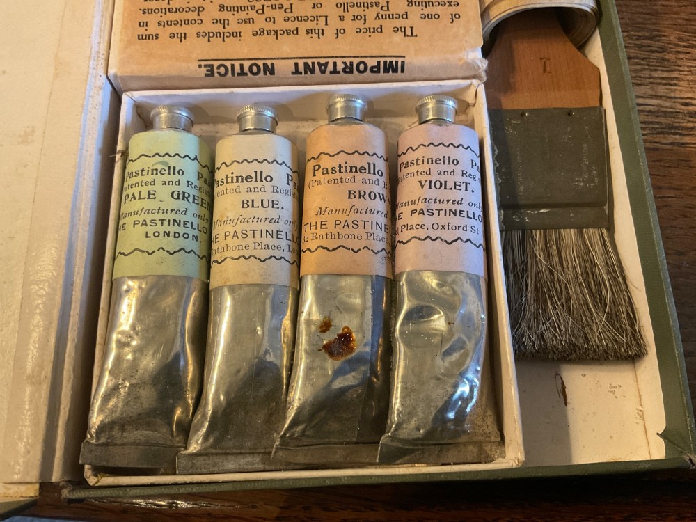 An open early 20th-century Workers Pastinello Outfit cardboard box containing paint tubes, a broad brush, and paper instructions. View V