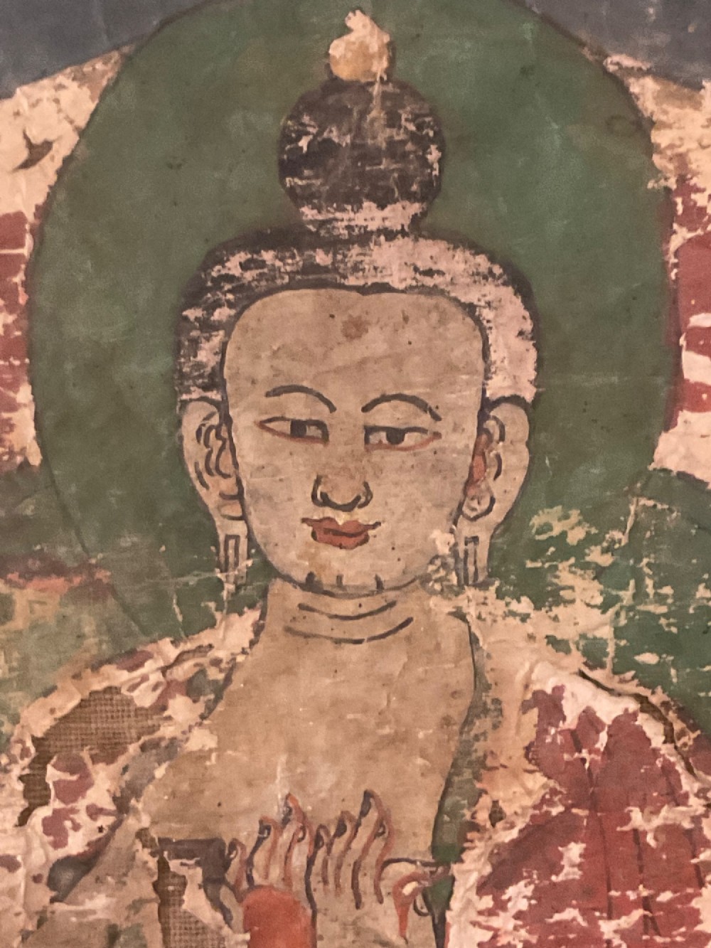 Framed 17th-century Tibetan canvas painting depicting the seated Vairocana Buddha with a red and green halo. View II