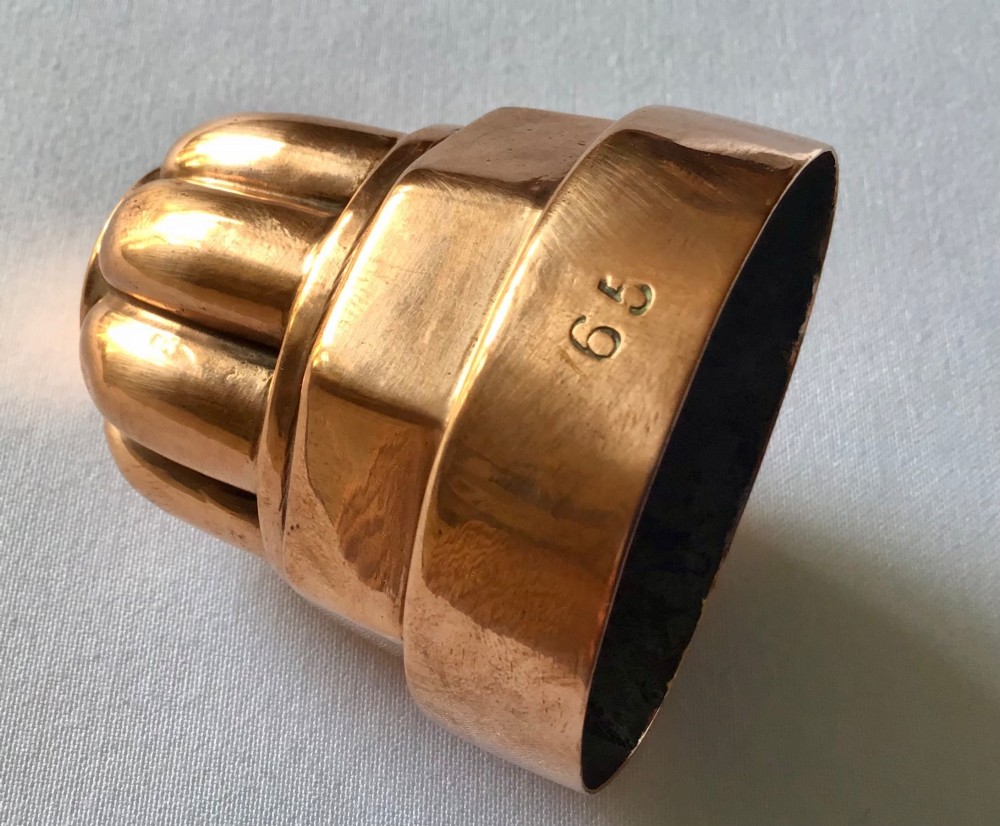 A small tiered Victorian copper jelly mould featuring a fluted top section, an octagonal middle band, and a round polished base. View II