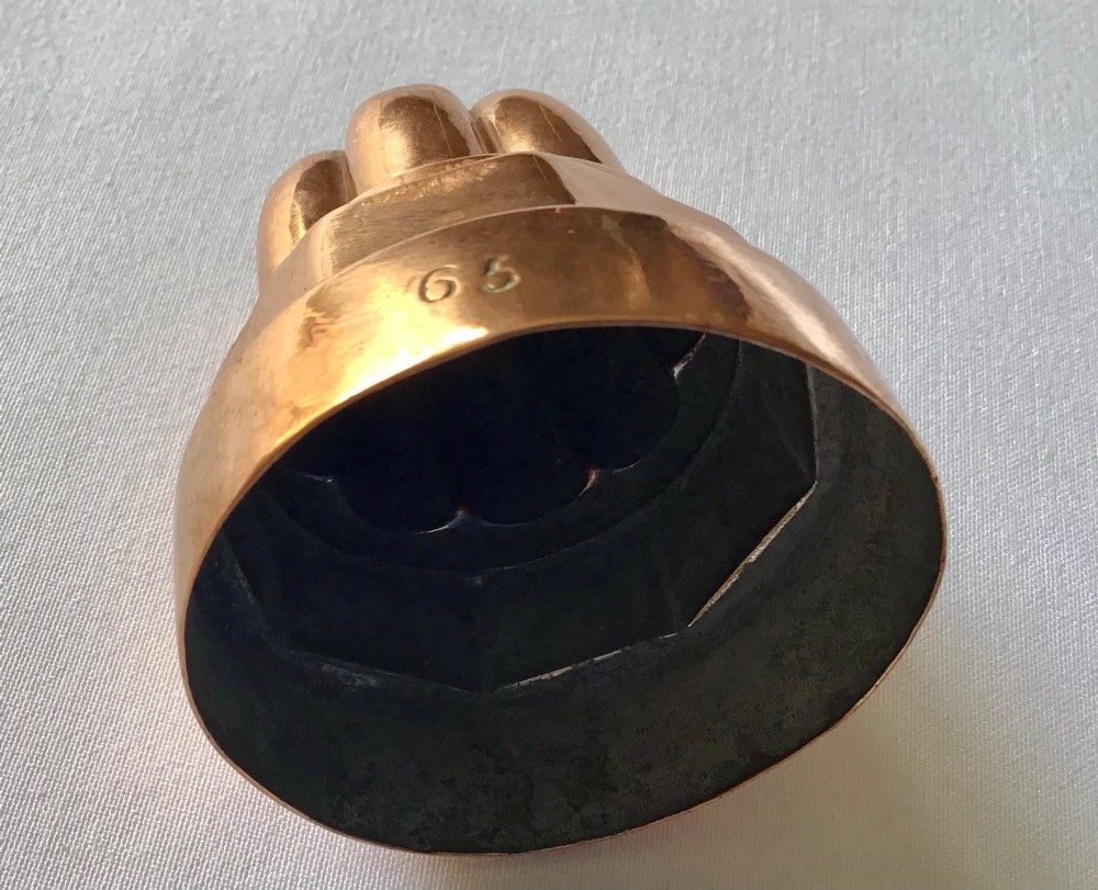 A small tiered Victorian copper jelly mould featuring a fluted top section, an octagonal middle band, and a round polished base. View III