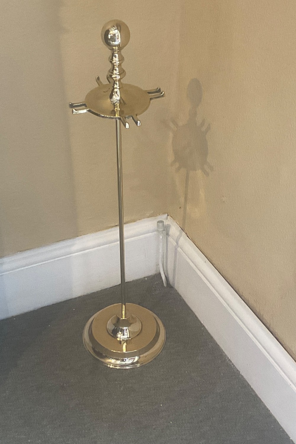 A polished brass companion set featuring a central stand with sphere finials holding a shovel, tongs, poker, and hearth brush. View VI
