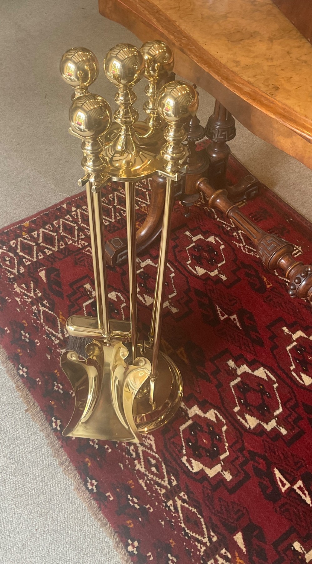A polished brass companion set featuring a central stand with sphere finials holding a shovel, tongs, poker, and hearth brush. View VII