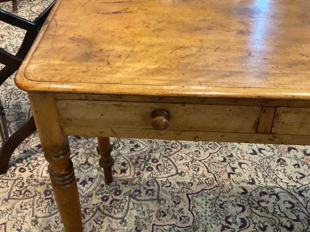 A Victorian satin walnut side table featuring two frieze drawers with wooden knob handles and four turned legs. View II
