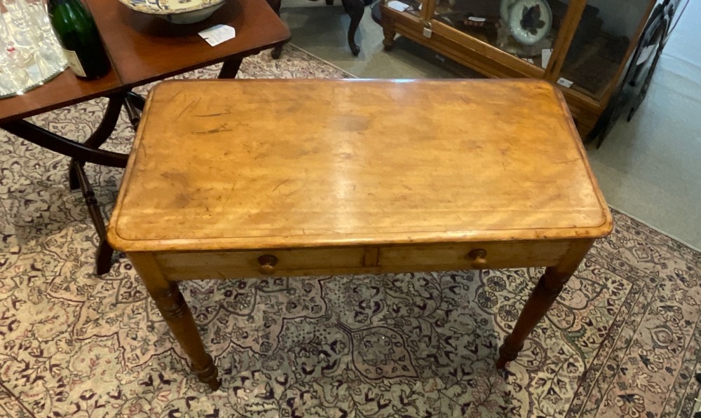 A Victorian satin walnut side table featuring two frieze drawers with wooden knob handles and four turned legs. View V