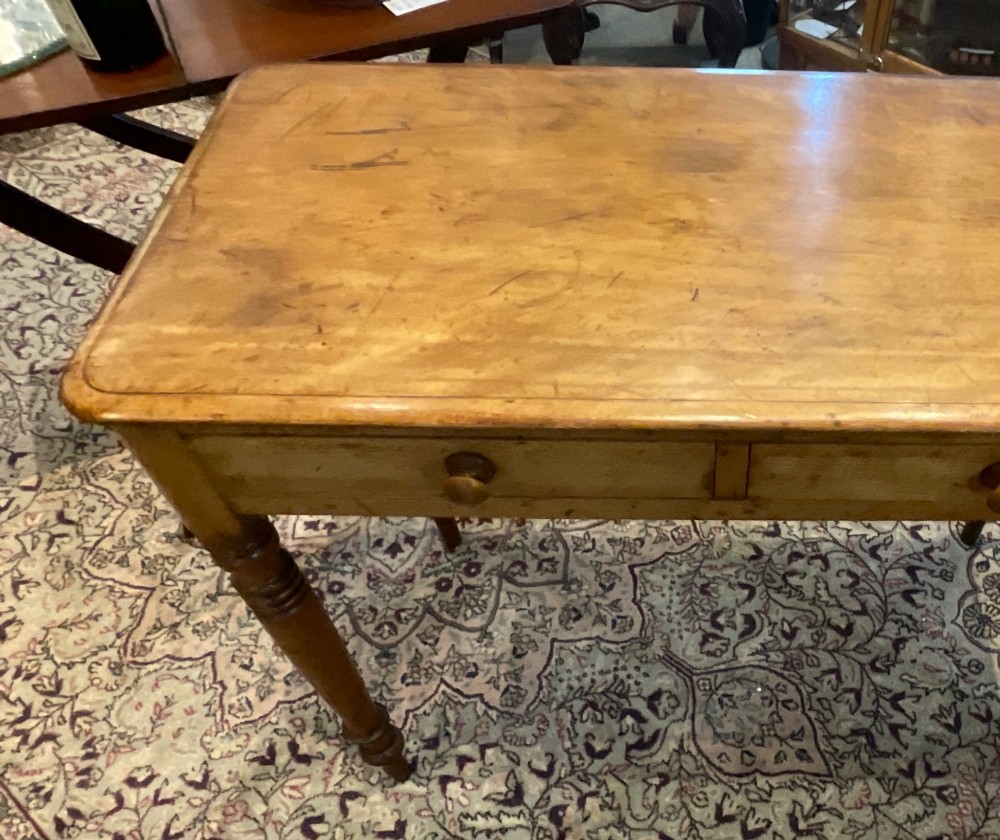 A Victorian satin walnut side table featuring two frieze drawers with wooden knob handles and four turned legs. View VII