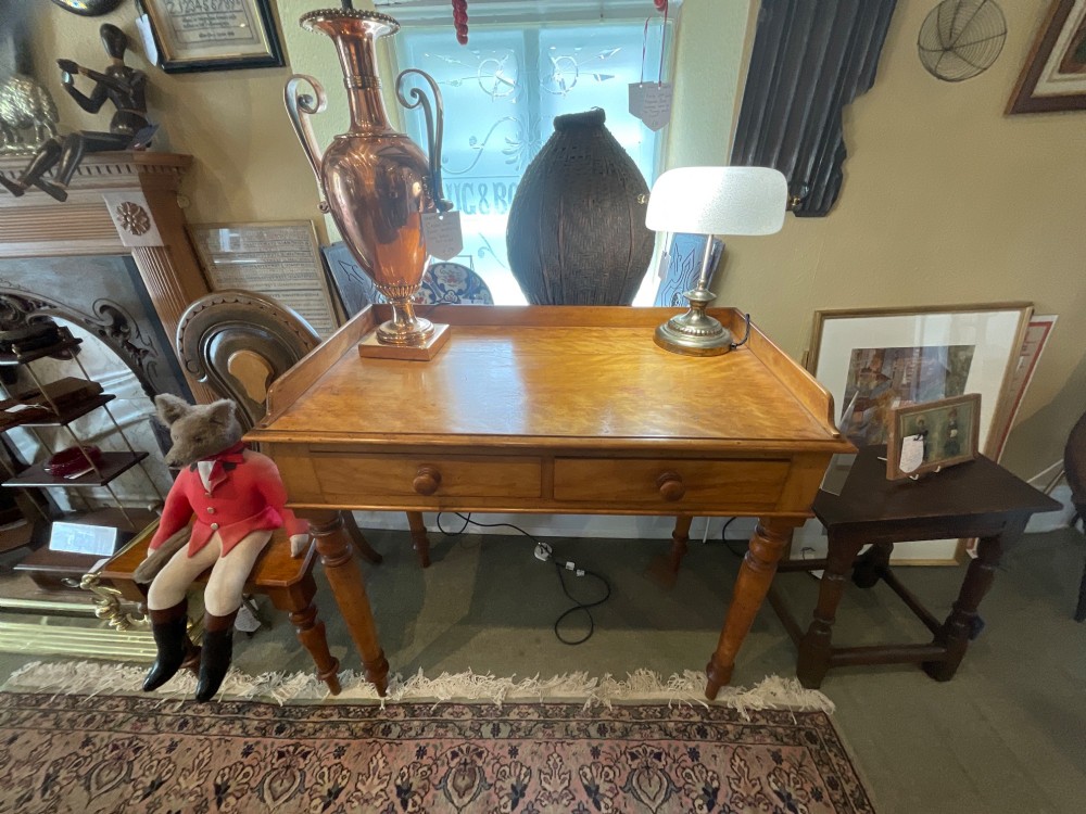 A Victorian satin birch writing desk featuring a three-quarter gallery top, two frieze drawers with turned wooden knobs, and four turned legs. View III