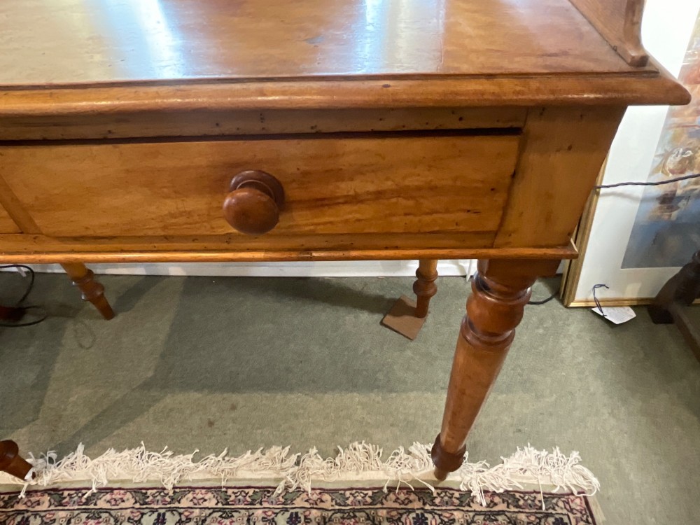 A Victorian satin birch writing desk featuring a three-quarter gallery top, two frieze drawers with turned wooden knobs, and four turned legs. View V